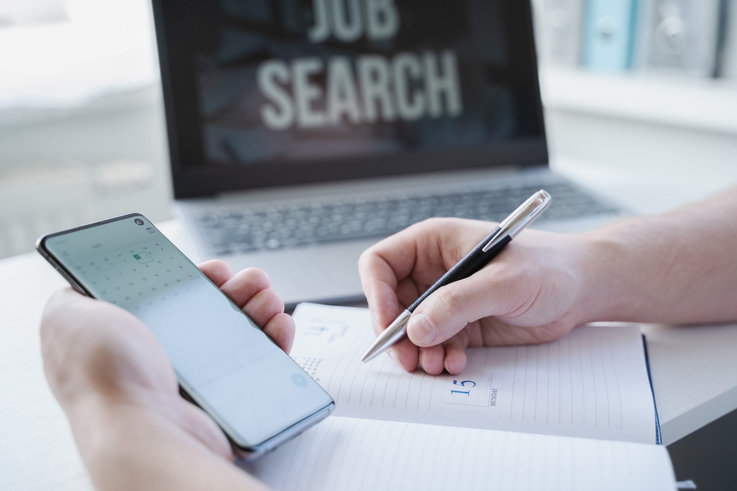 Hand writing on a notebook during job searching.