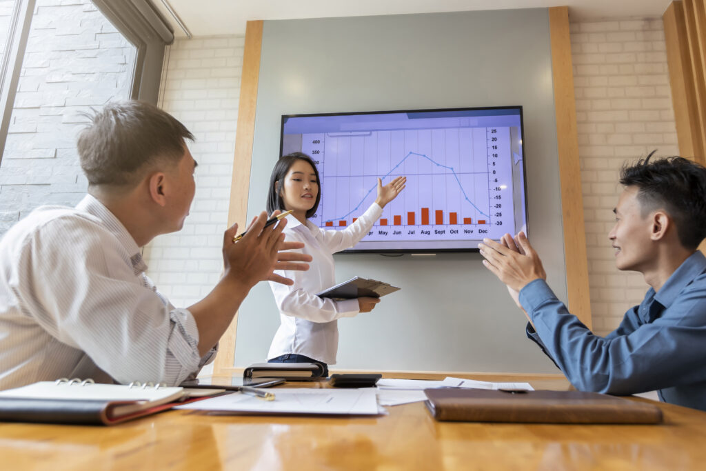 A sales team lead presenting sales performance data to her team members.